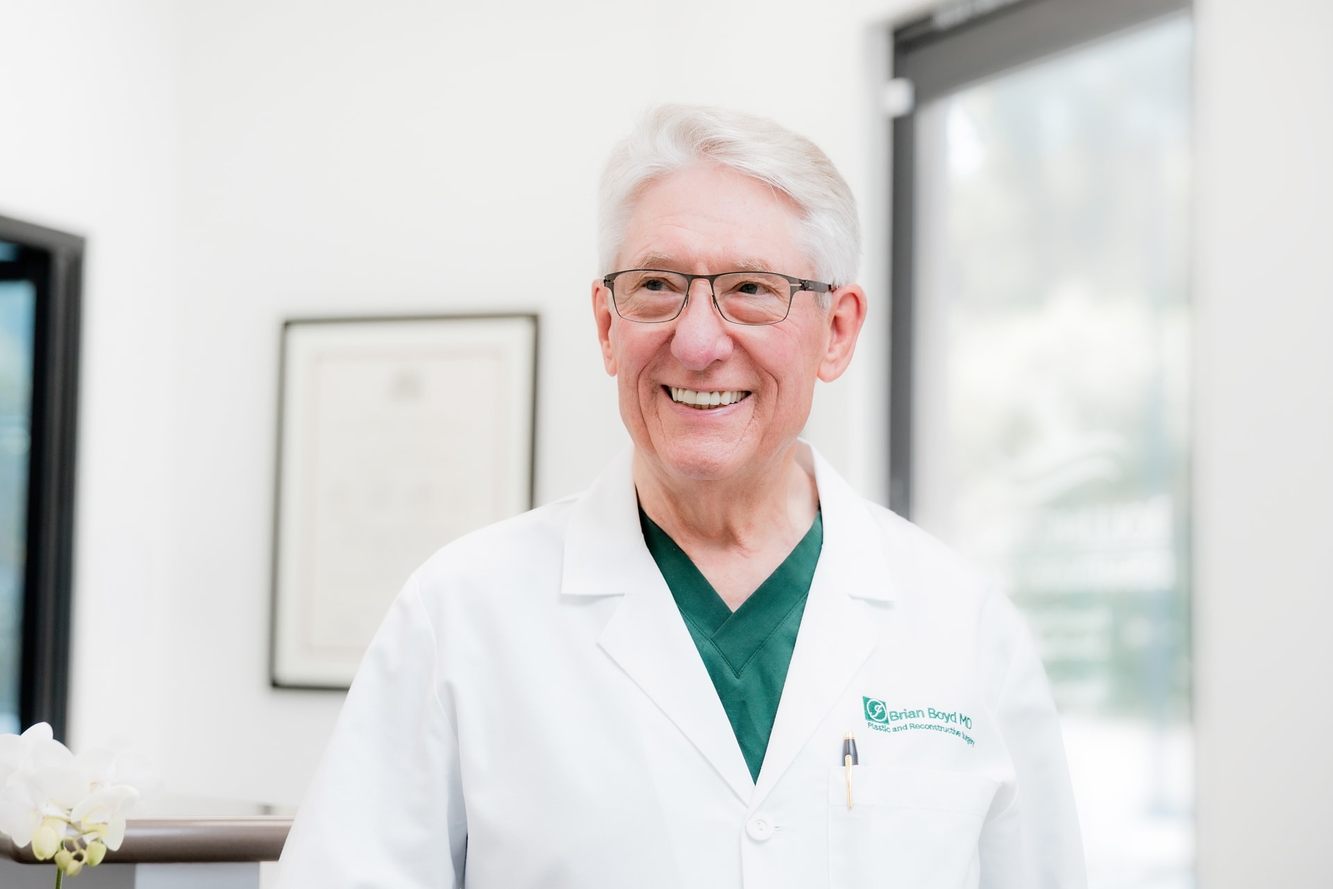 Dr. Brian Boyd wearing green scrubs and white lab coat