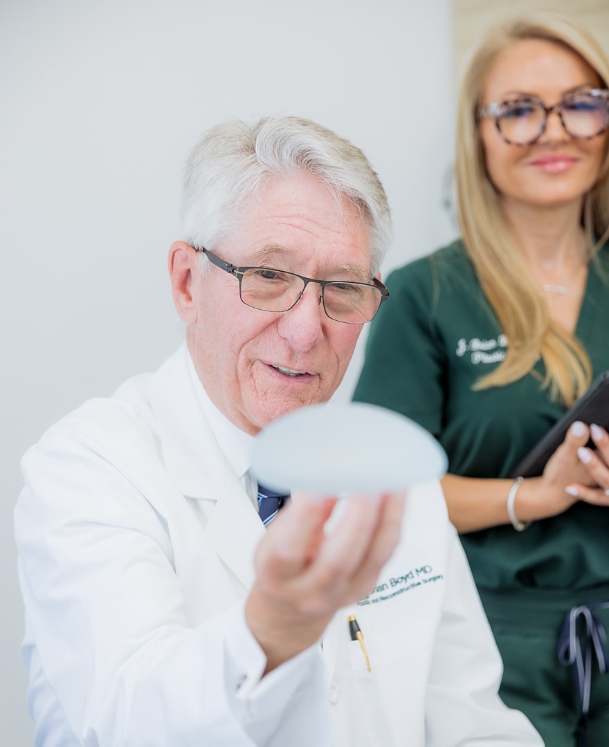 Dr. Boyd holding a breast implant