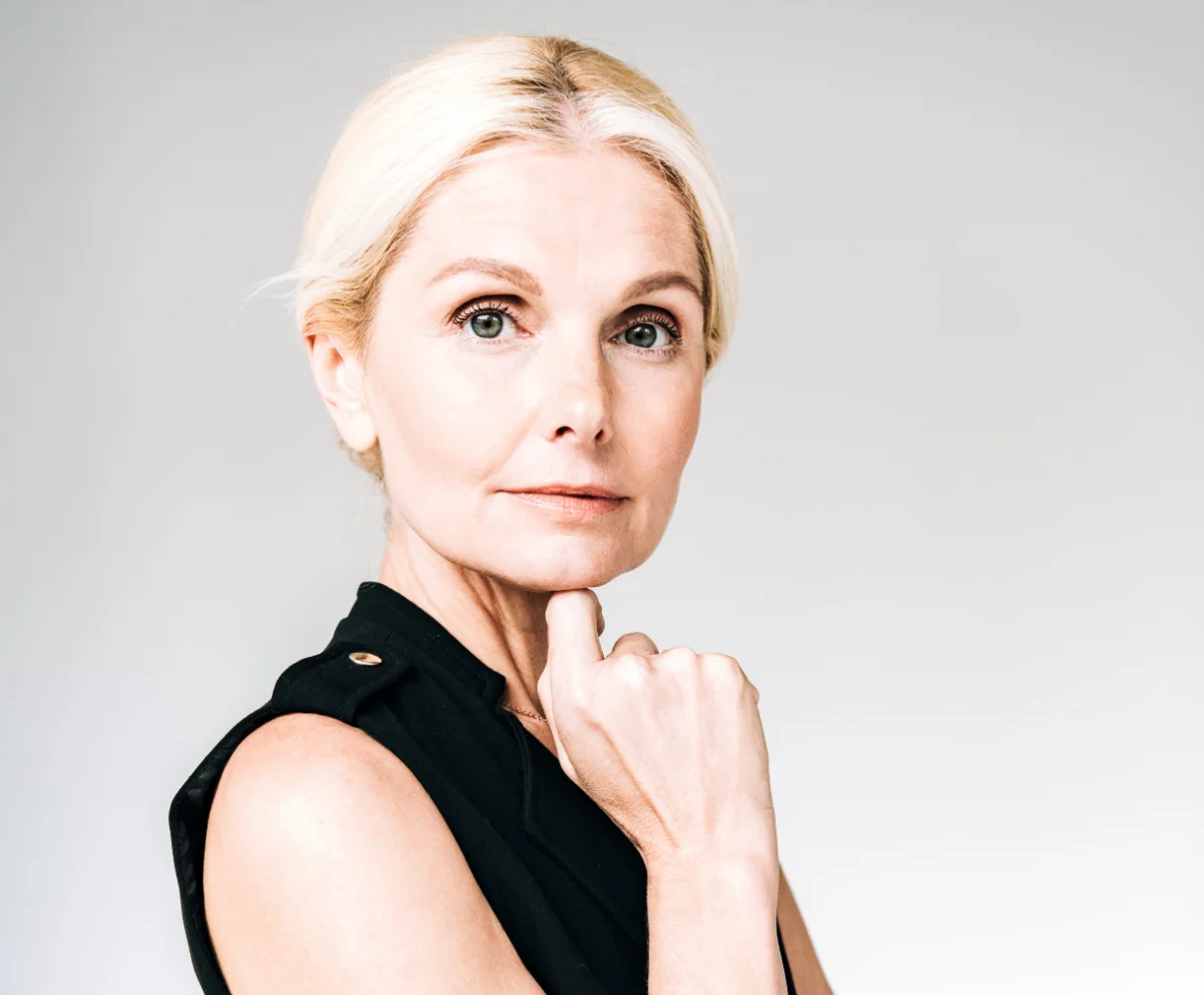 blond mature woman touching her chin